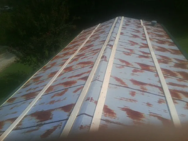 Rusted metal roof panels with new wood purlins before replacement — Storm Damage Roof Repair in Clarendon by Roofing Brothers